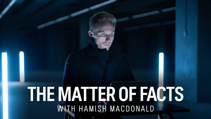 Promotional hero image for the program The Matter of Facts with Hamish Macdonald, featuring Hamish Macdonald looking at a laptop in a dark, blue-lit studio.