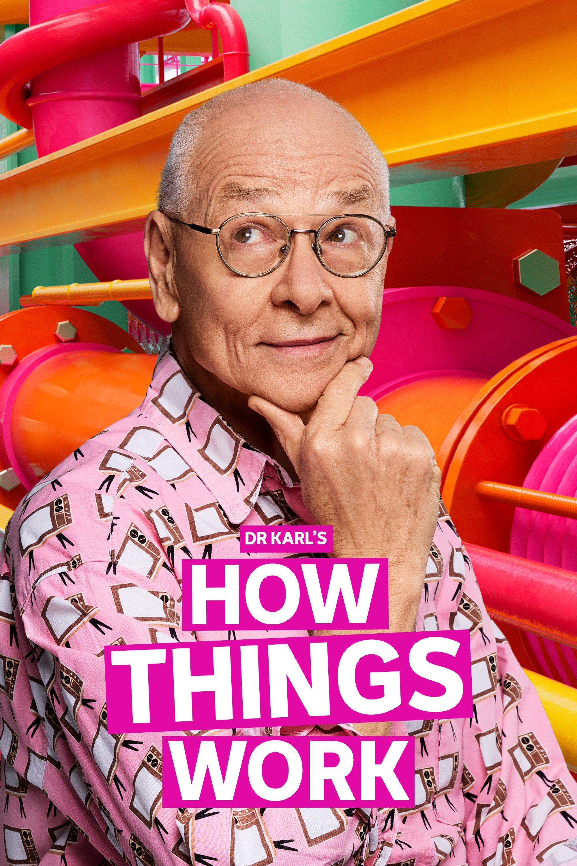 Dr Karl, wearing a pink patterned shirt and glasses, poses thoughtfully with his hand on his chin. He is set against a vibrant background of colorful pipes and machinery. The title Dr Karl’s How Things Work is displayed in bold white and pink text.