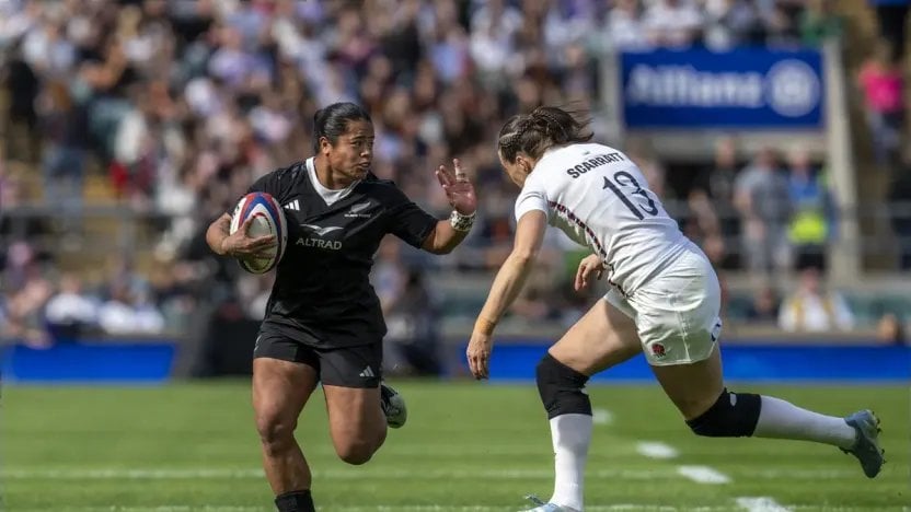 A Black Ferns player carries the ball towards an England defender