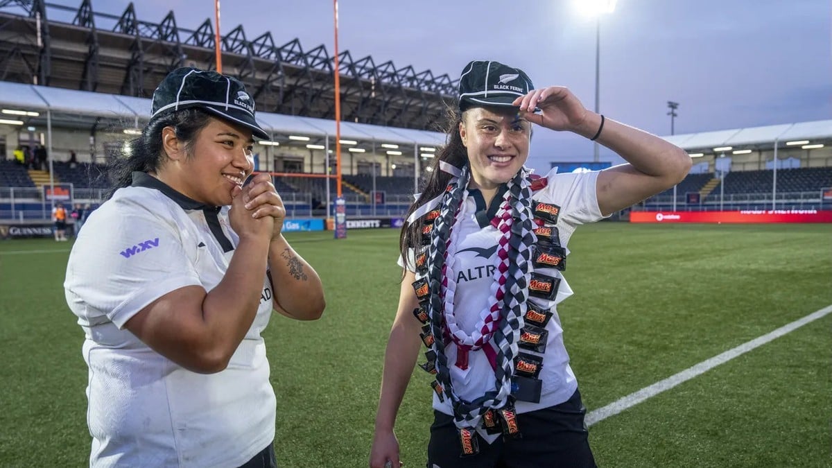 Two Black Ferns players wearing their Test caps and garlands on the field