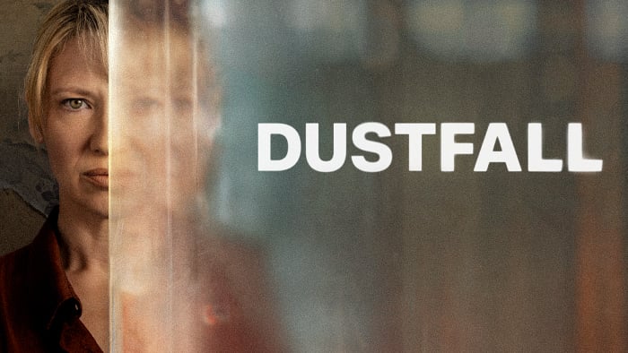 Promotional image for Dustfall, showing Anna Torv partially hidden behind a glass pane with the show title beside her.
