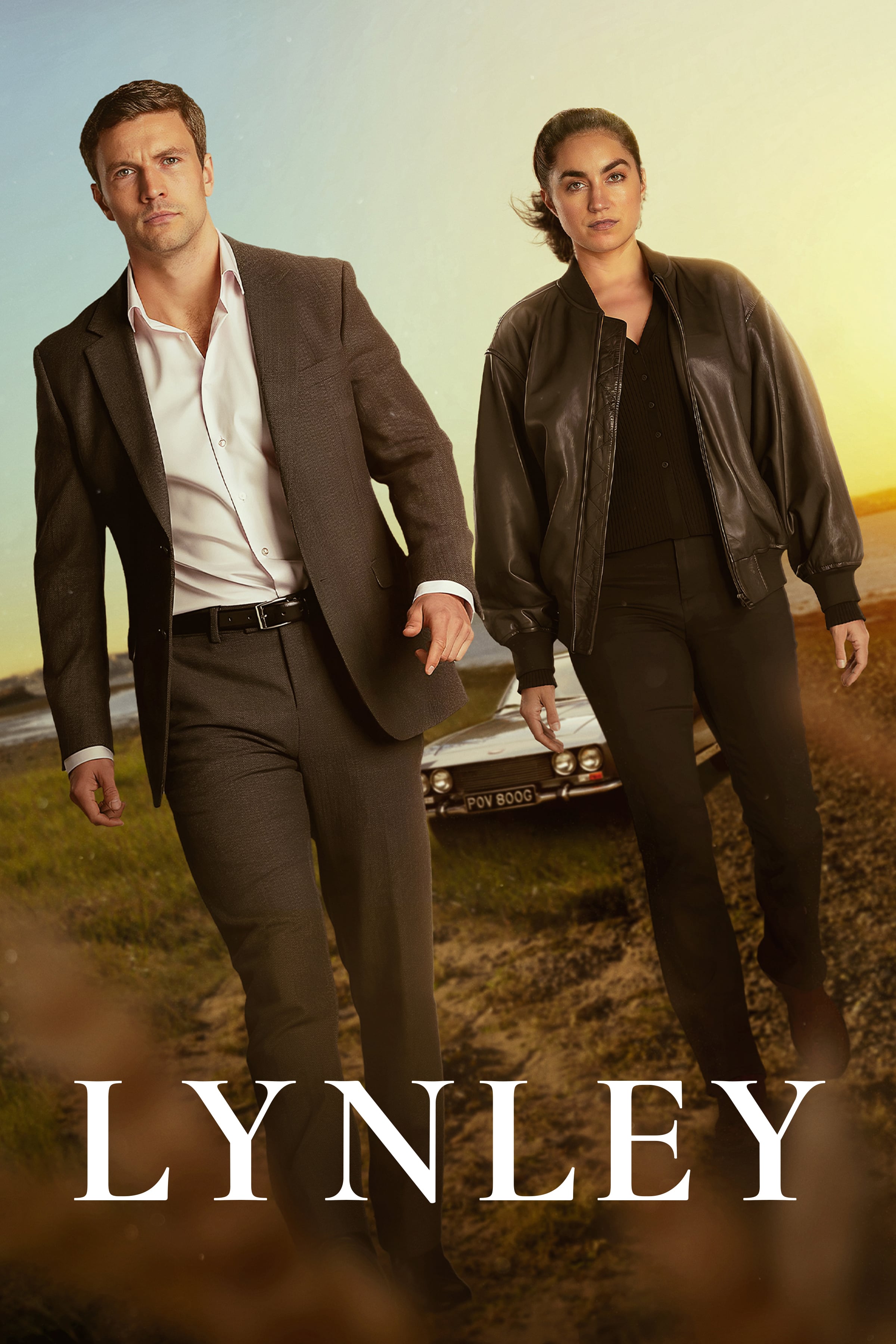 Poster for Lynley, showing detectives Tommy Lynley and Barbara Havers standing in front of a car on a coastal road at sunset.